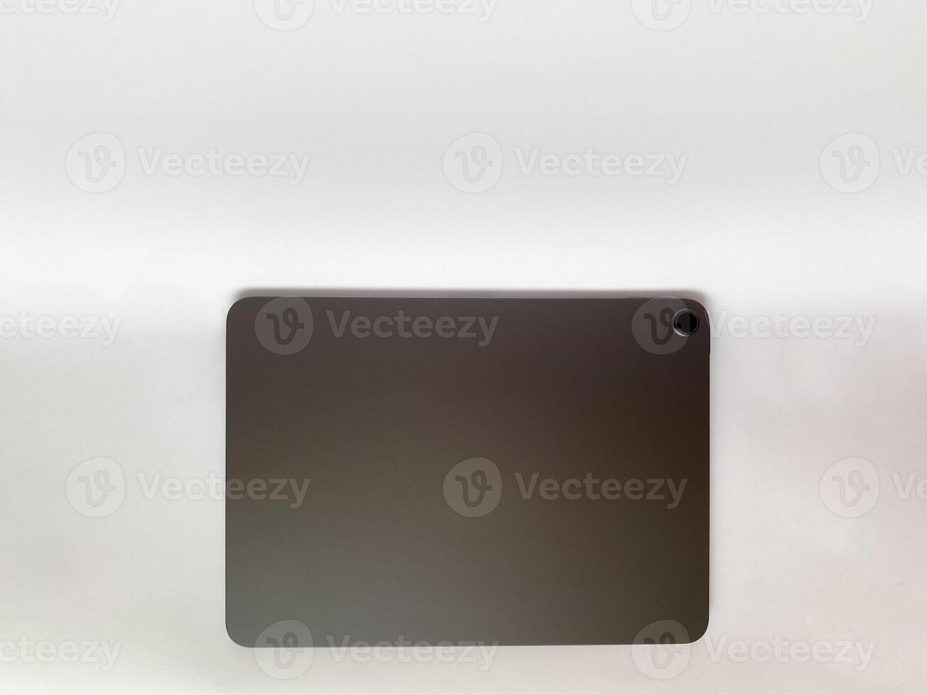 The tablet is black on a white isolated background with a mock up. Back side view of the tablet photo