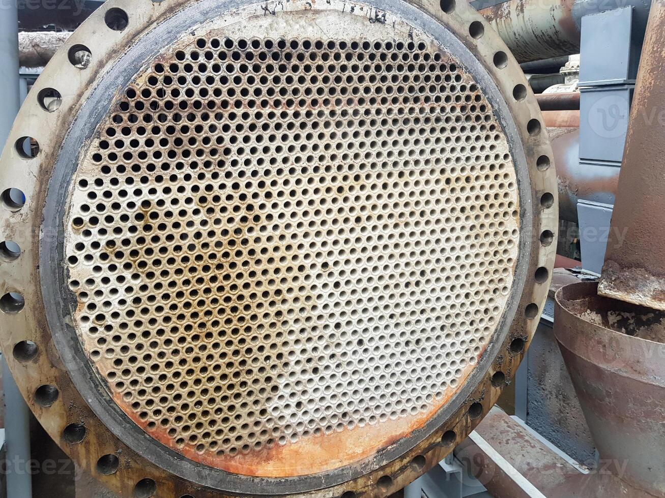 Shell-and-tube heat exchanger for heat exchange between two streams close-up. Dirty pipes in the opened heat exchanger photo