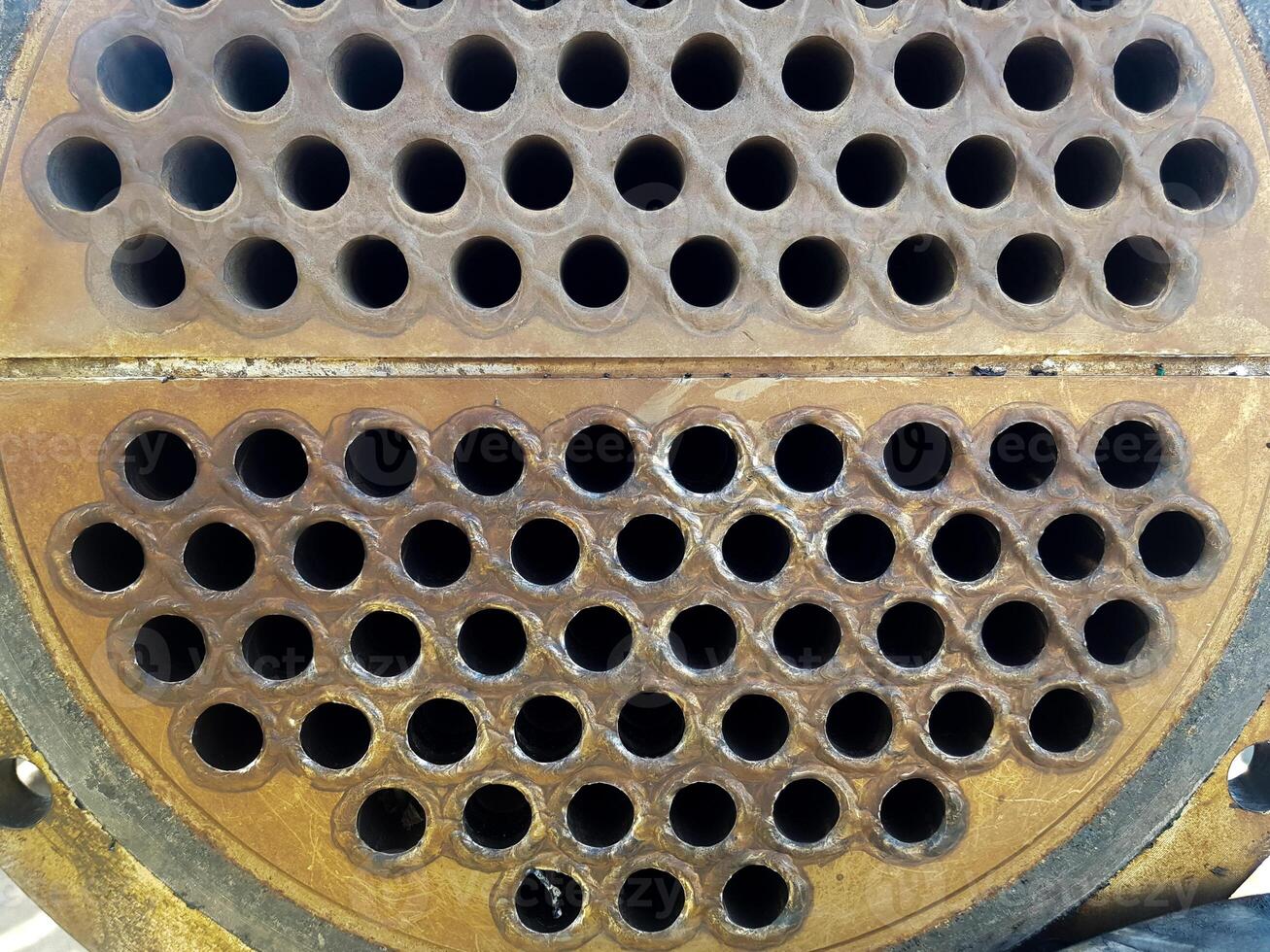 Shell-and-tube heat exchanger for heat exchange between two streams close-up. Dirty pipes in the opened heat exchanger photo