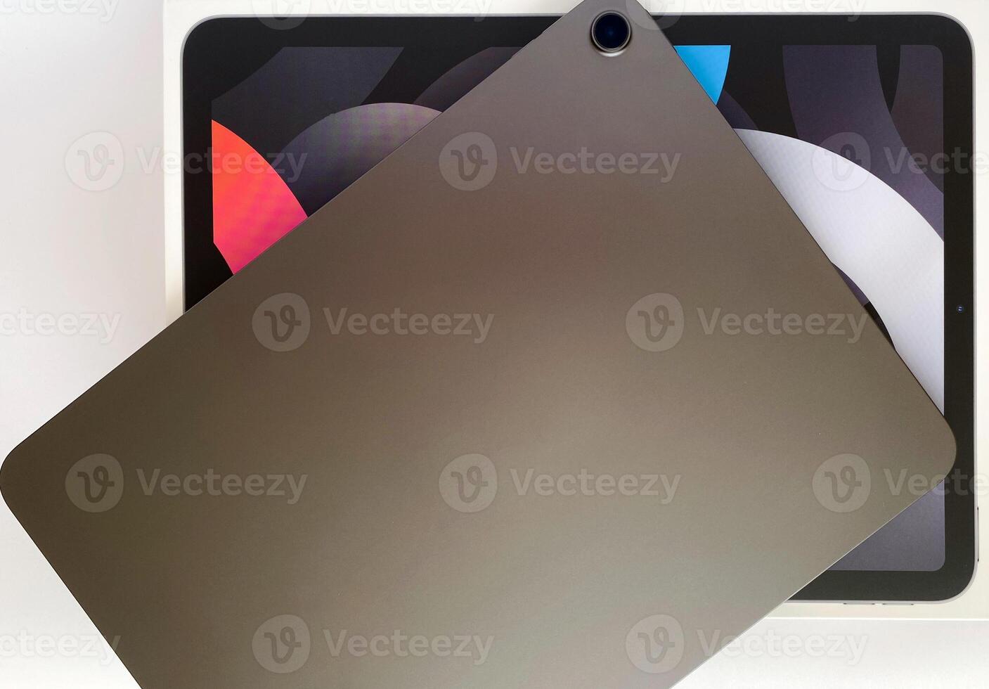 The tablet is black on a white isolated background with a mock up. Back side view of the tablet photo