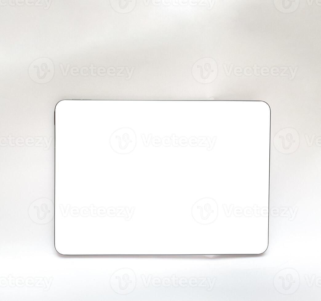 The tablet is black on a white isolated background with a mock up. Back side view of the tablet photo