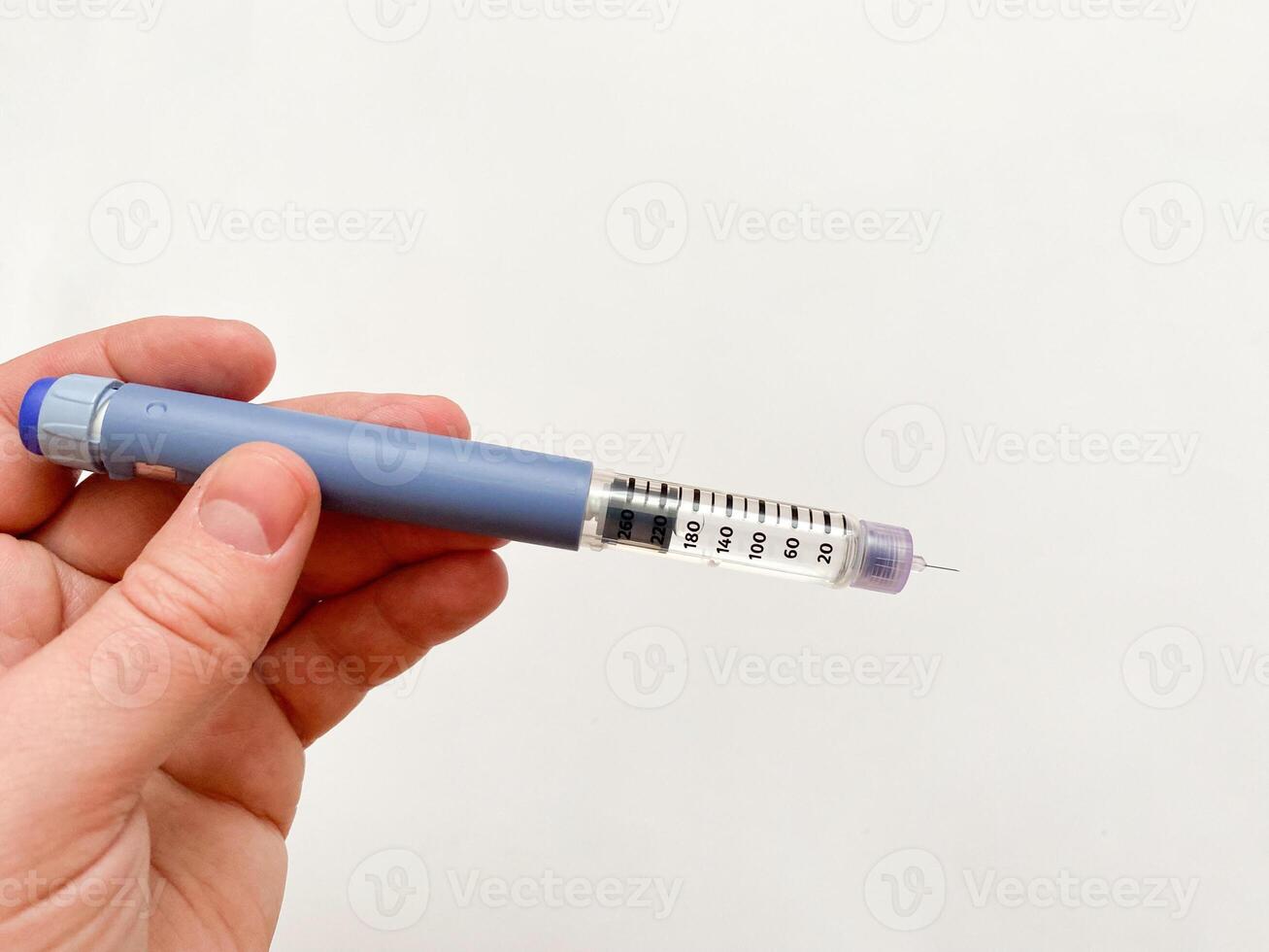 Insulin syringe-pen in hand on a white isolated background. Insulin for diabetics photo