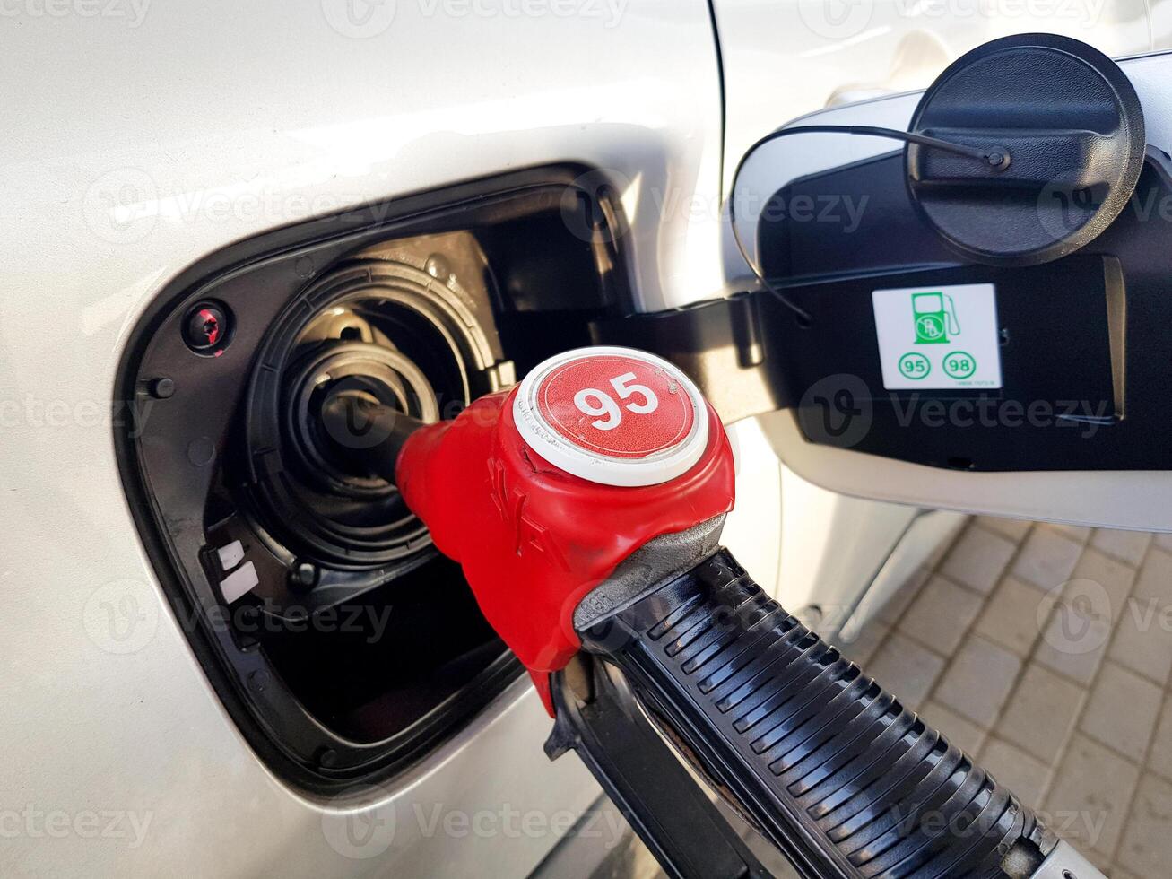 Filling the car with gasoline. Insert the red gun into the tank of the car for refueling. The process of refueling the car with fuel photo