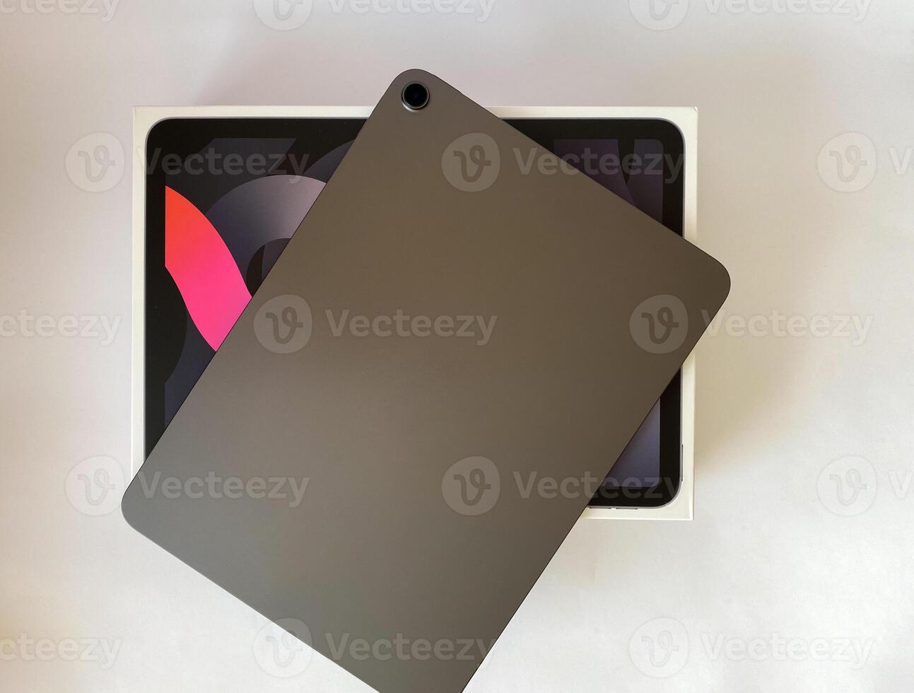 The tablet is black on a white isolated background with a mock up. Back side view of the tablet photo