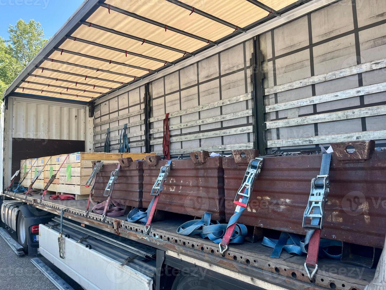 Cargo transportation of screws in wooden and metal boxes in a semi-trailer truck. Side loading of bolts photo