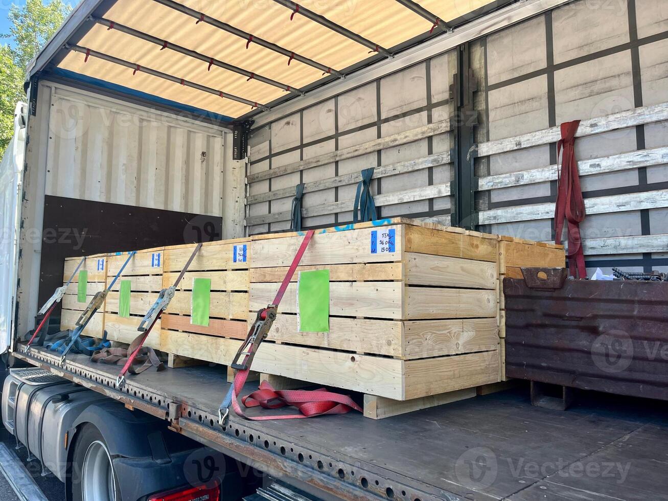 Cargo transportation of screws in wooden and metal boxes in a semi-trailer truck. Side loading of bolts photo