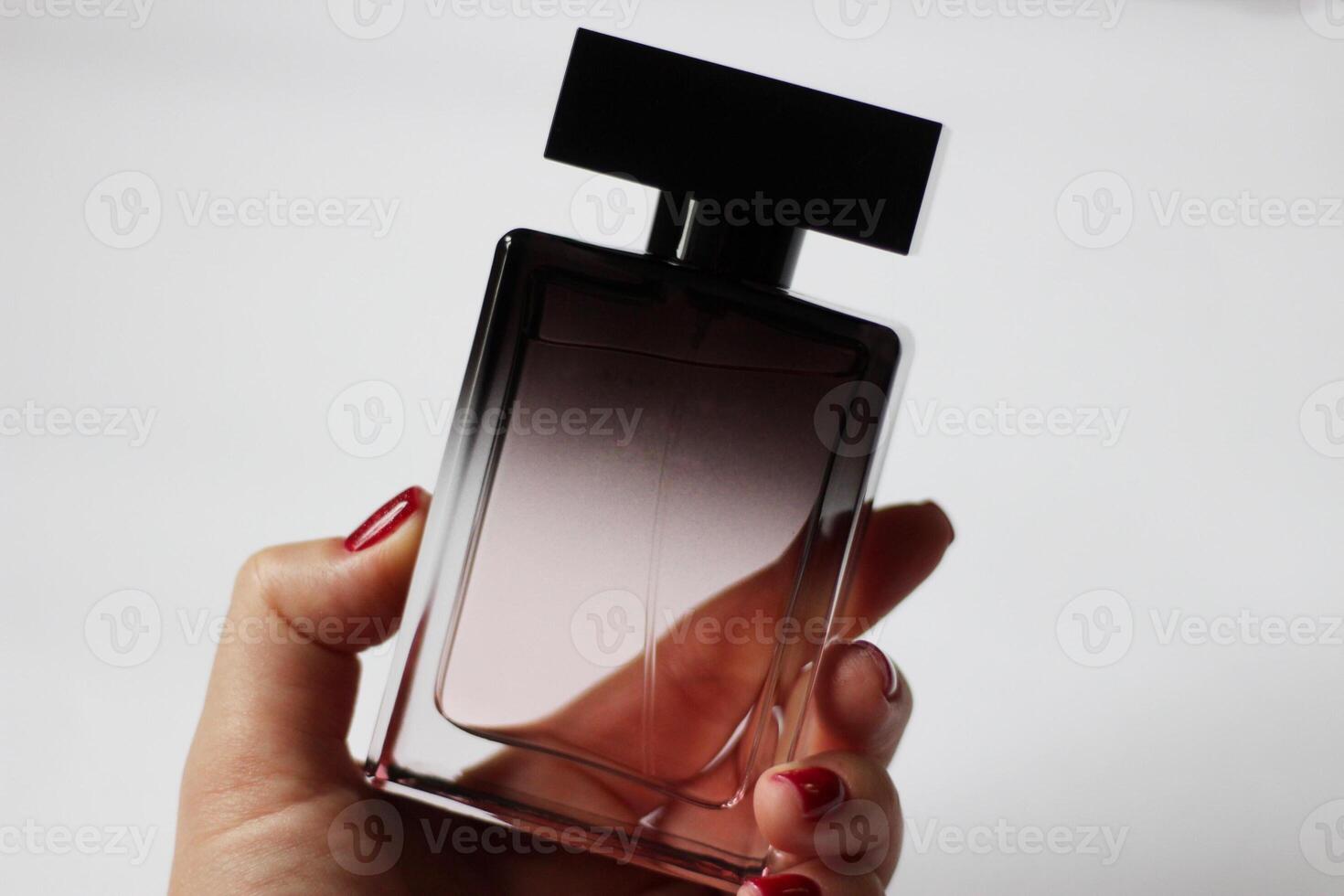 A bottle of black perfume in close-up on a white isolated background. Beautiful perfume for a gift photo