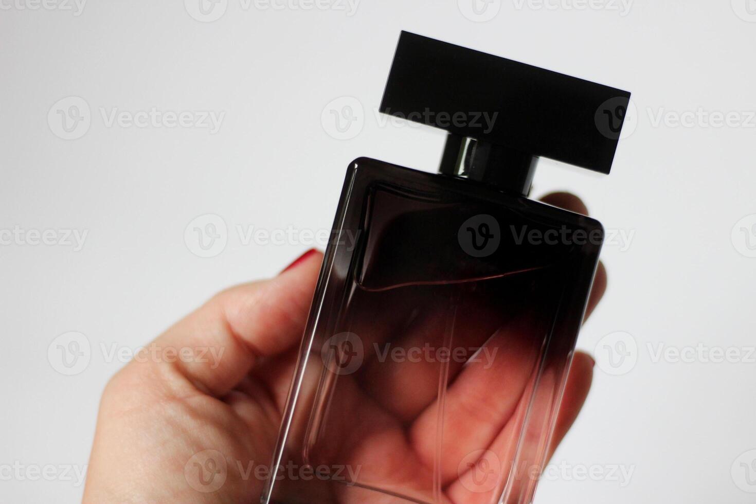 A bottle of black perfume in close-up on a white isolated background. Beautiful perfume for a gift photo
