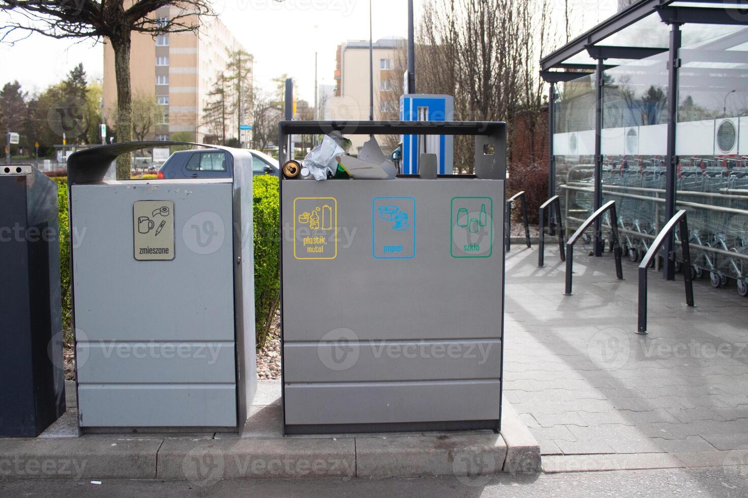 Public garbage bin with waste separation on a city street filled with garbage photo