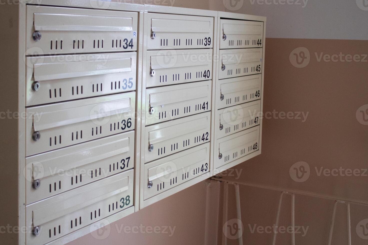 Numbered mailboxes in the entrance of an apartment building photo