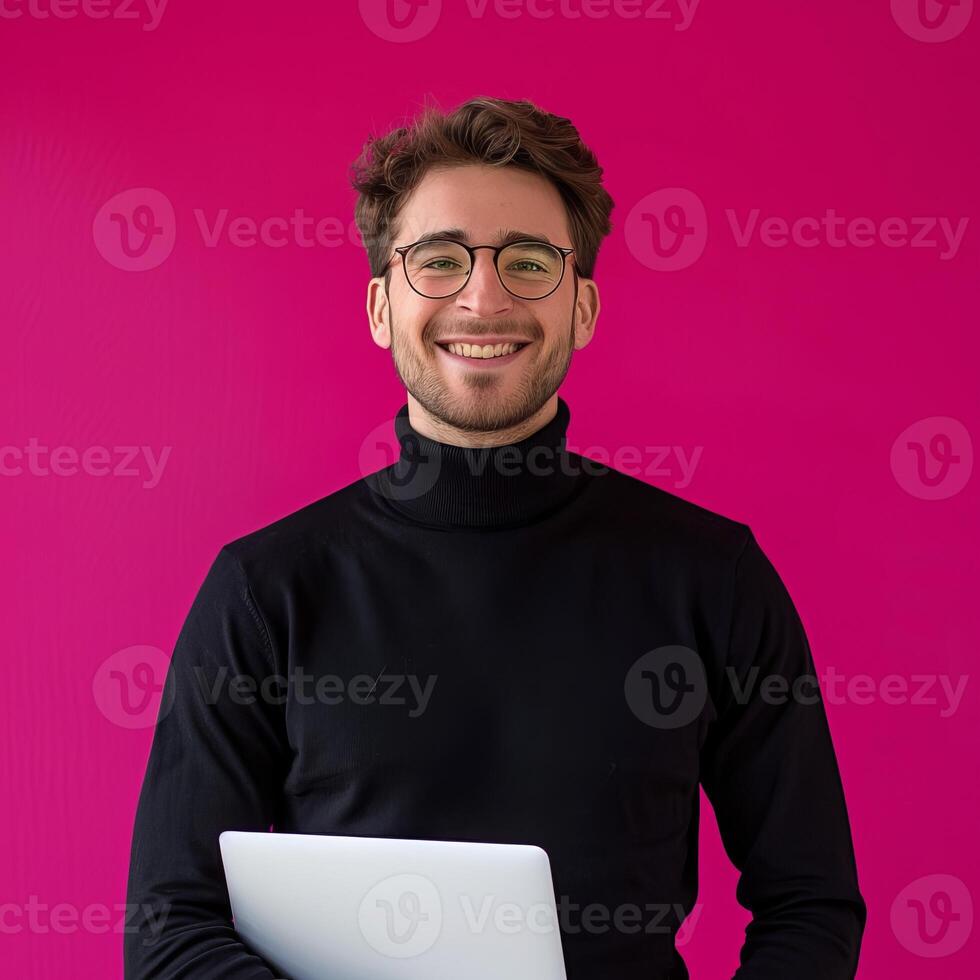 Smiling Man With Laptop In Front Of Pink Background photo