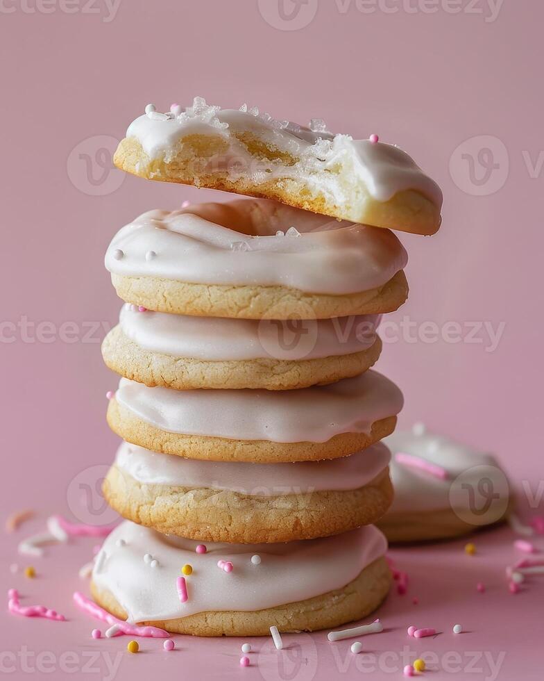 Stack of Frosted Sugar Cookies With Sprinkles on Pink Background photo