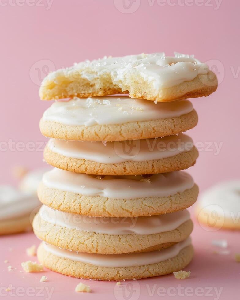 Stack of Six White Frosted Sugar Cookies on a Pink Surface photo