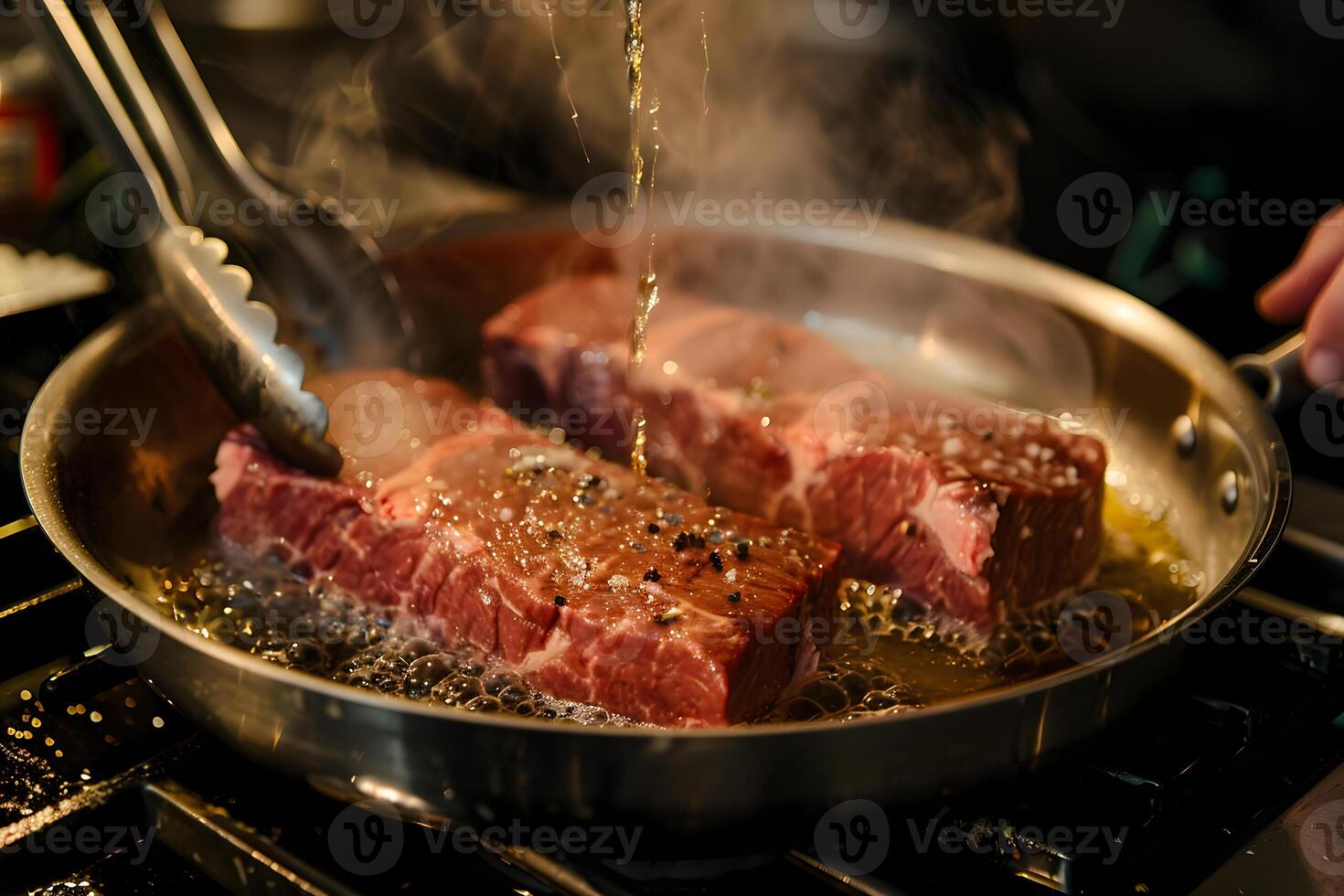 Cooking steak in a pan with tongs and steam rising photo