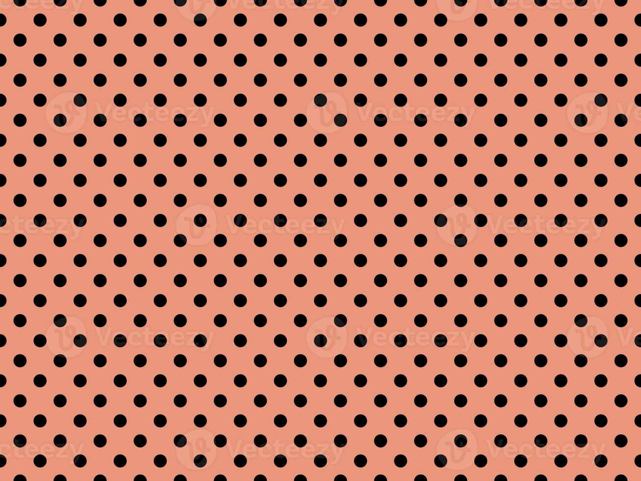 black polka dots over dark salmon background photo