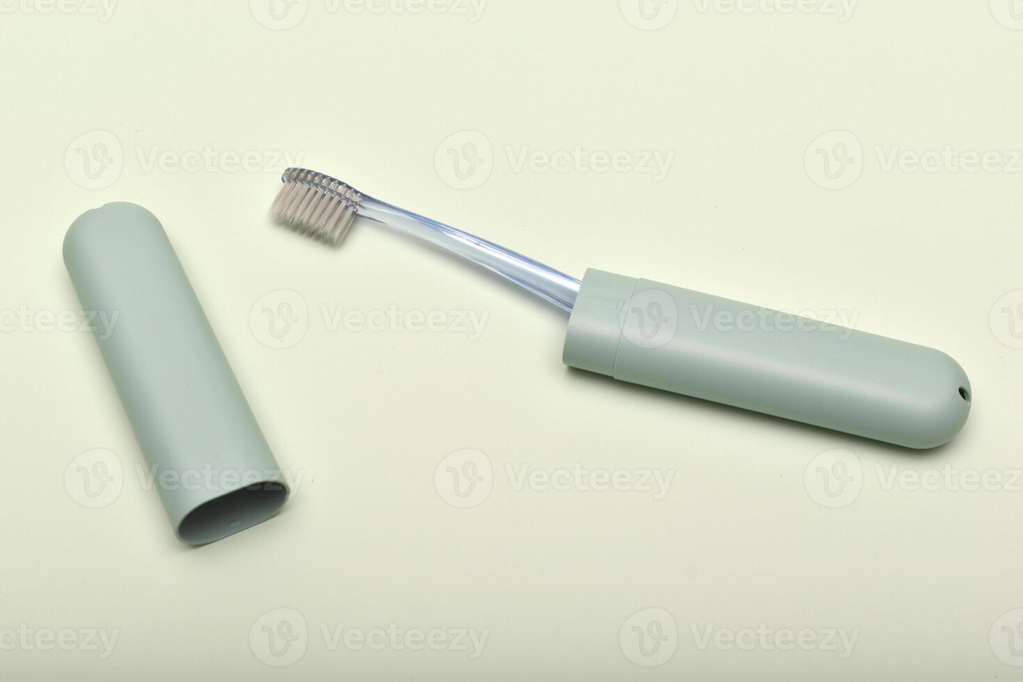 A toothbrush case and a toothbrush on a green background. photo