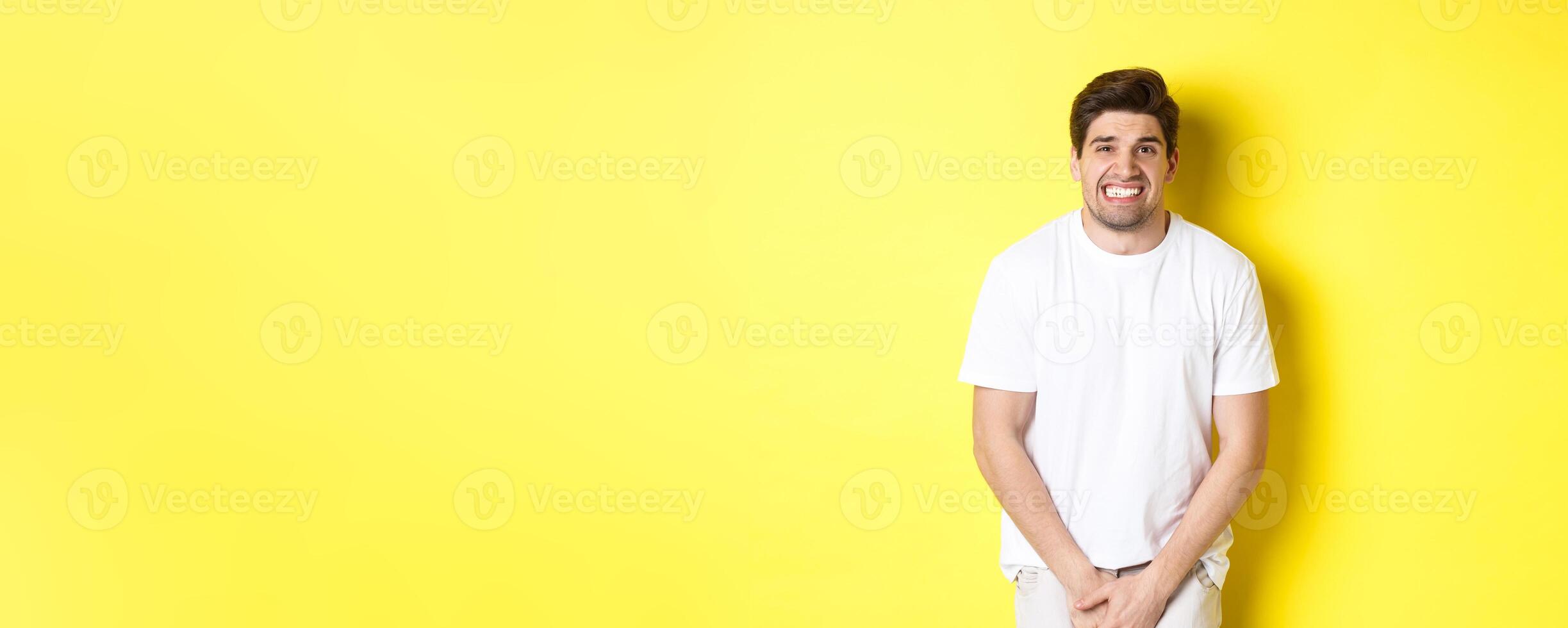 Bladder problem. Man need to toilet, holding hands on crotch and grimacing, urinal dysfunction. Copy space photo
