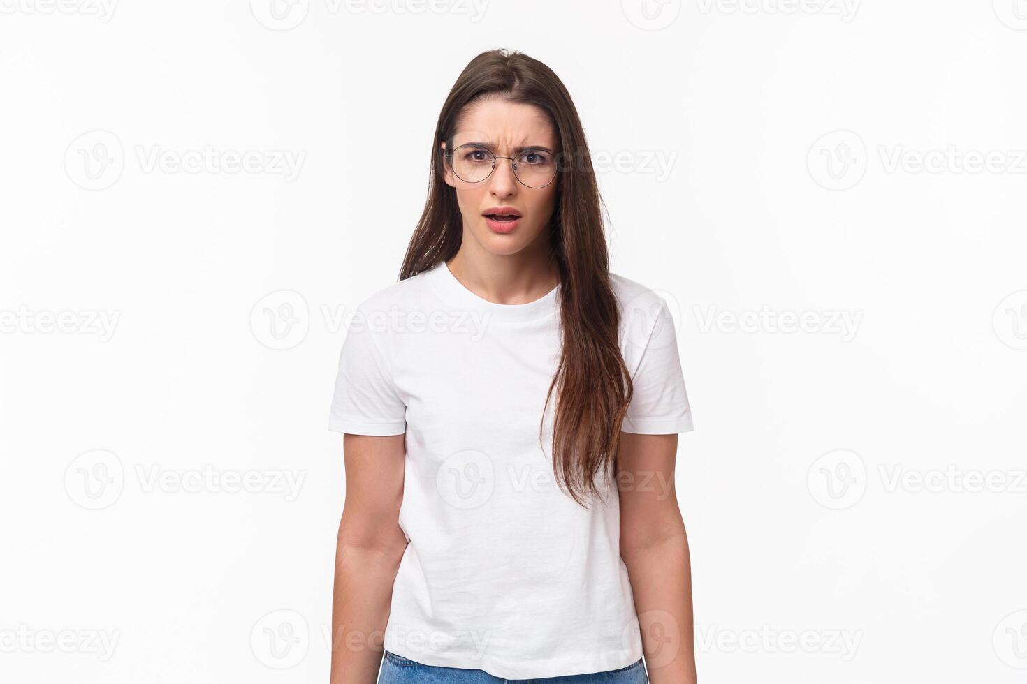 Waist-up portrait of frustrated and shocked young female coworker hear strange confession, freak out, frowning and grimaccing tensed and disappointed, dont agree and like idea, white background photo