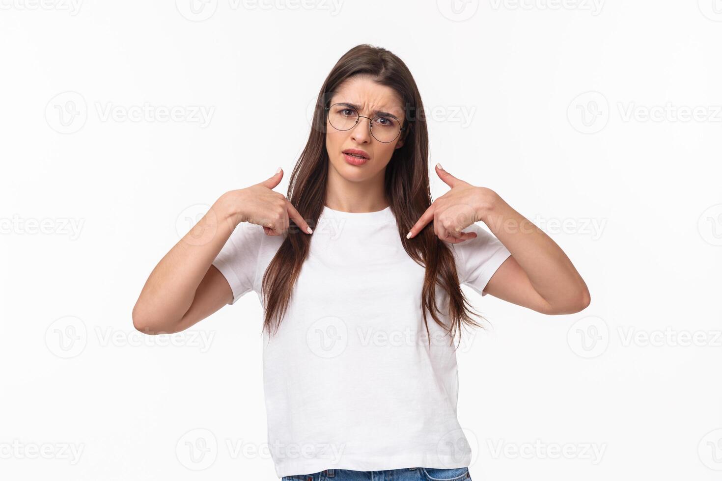 Waist-up portrait of insulted, shocked and offended young frustrated woman pointing at herself, grimace puzzled and confused, cant understand why she was picked or accused photo