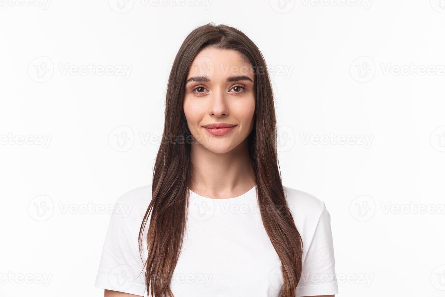 Close-up portrait of beautiful young woman, modern girl with long chestnut hair and no pimples, standing simple shirt and smiling camera, positive friendly expression, white background photo