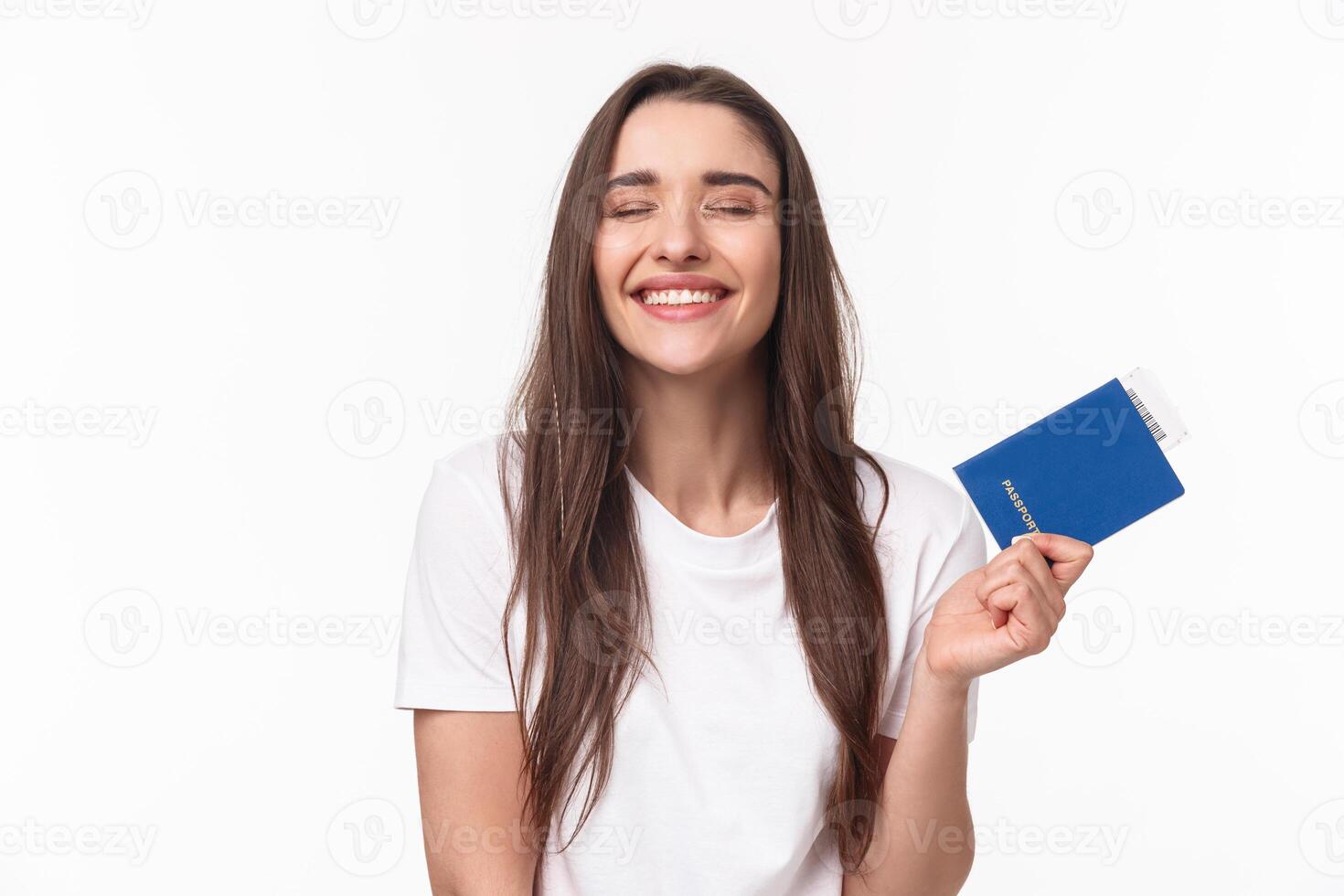 Travelling, holidays, summer concept. Dreamy happy young beautiful girl in white t-shirt, close eyes smiling, daydreaming how she sunbathing near beach on vacation, hold passport with ticket photo