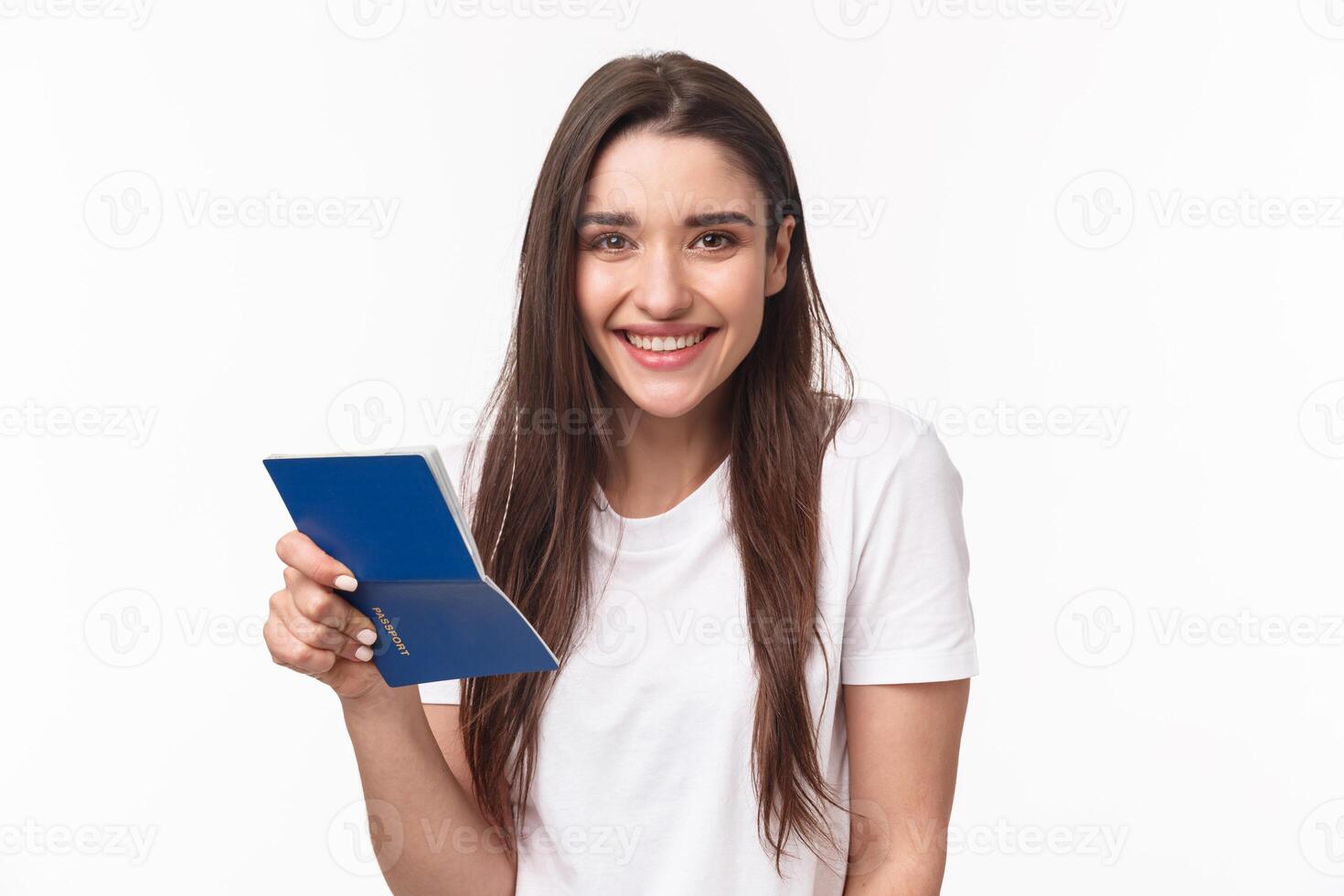 Travelling, holidays, summer concept. Close-up portrait of cute, happy pretty young woman in t-shirt, holding opened passport and smiling, standing in airport terminal going for journey, vacation photo