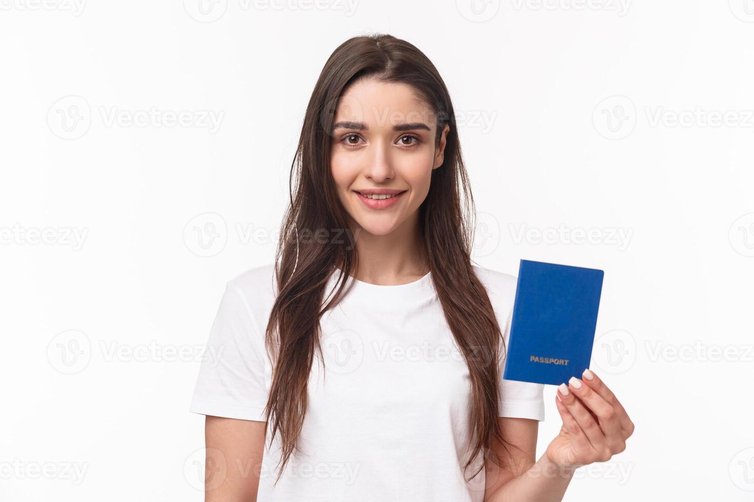 Travelling, holidays, summer concept. Close-up portrait of caucasian smiling happy woman in t-shirt, holding passport with and looking camera, buying flight ticket waiting for her plane in terminal photo