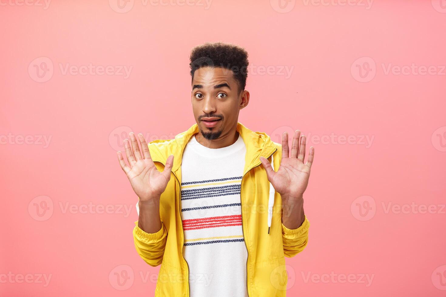 Guy staying out of troubles. Portrait of confused unsure clueless african american guy with beard raising palms in surrender gazing innocent at camera denying everything being unvinvolved photo