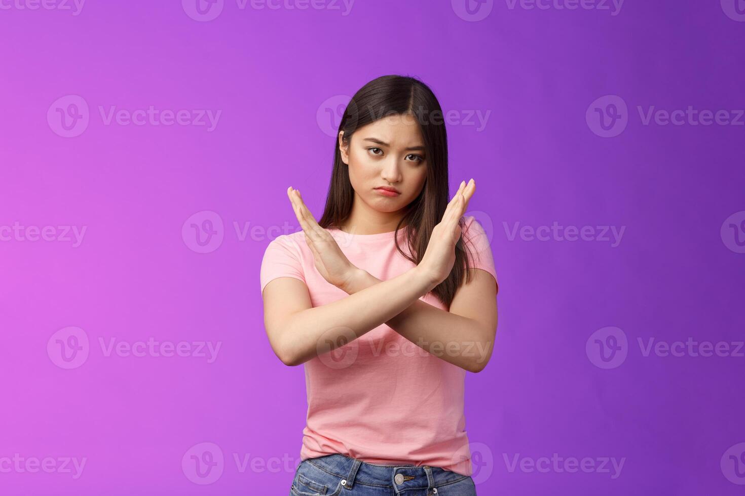 Serious-looking annoyed fed up asian girl demand stop, make arm cross chest forbidden gesture, look with scorn and disappointment, refusing terrible offer, give rejection, wanna end argument photo