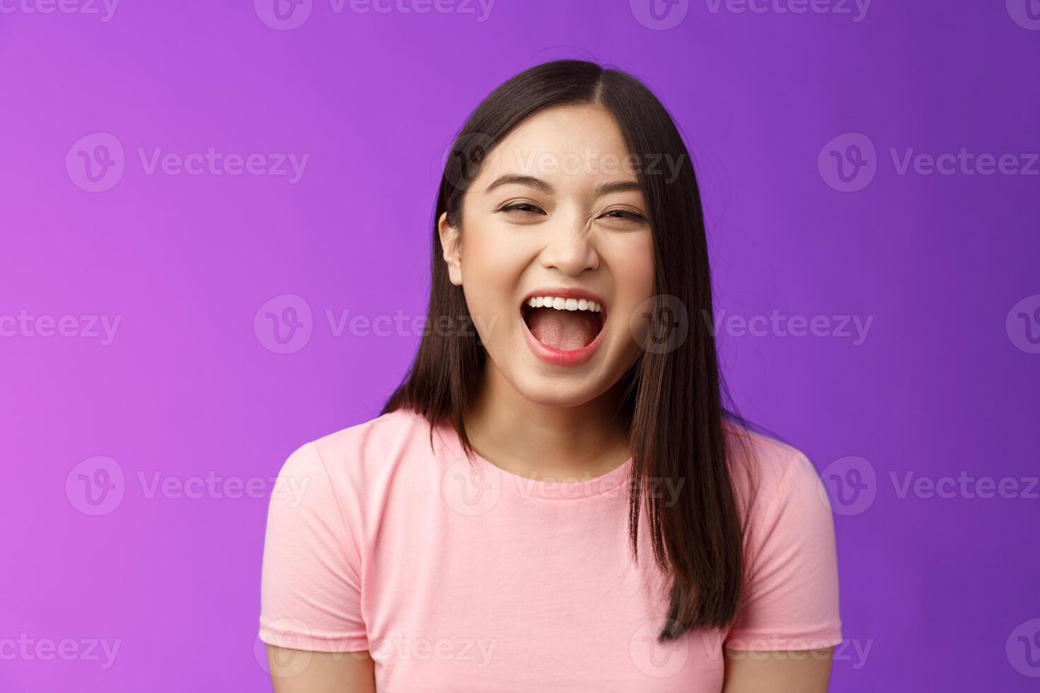 Close-up sincere carefree asian brunette laughing out loud, enjoy comedy movie, having fun, joking friends, stand entertained purple background amused, express positive emotions photo