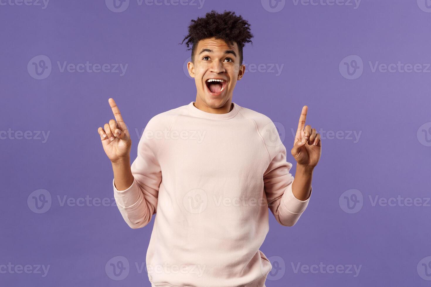 Charismatic good-looking young 25s hispanic guy rejoicing over super cool offer, best deal ever, seeing favorite product finally in stock, pointing fingers up smiling and laughing from happiness photo