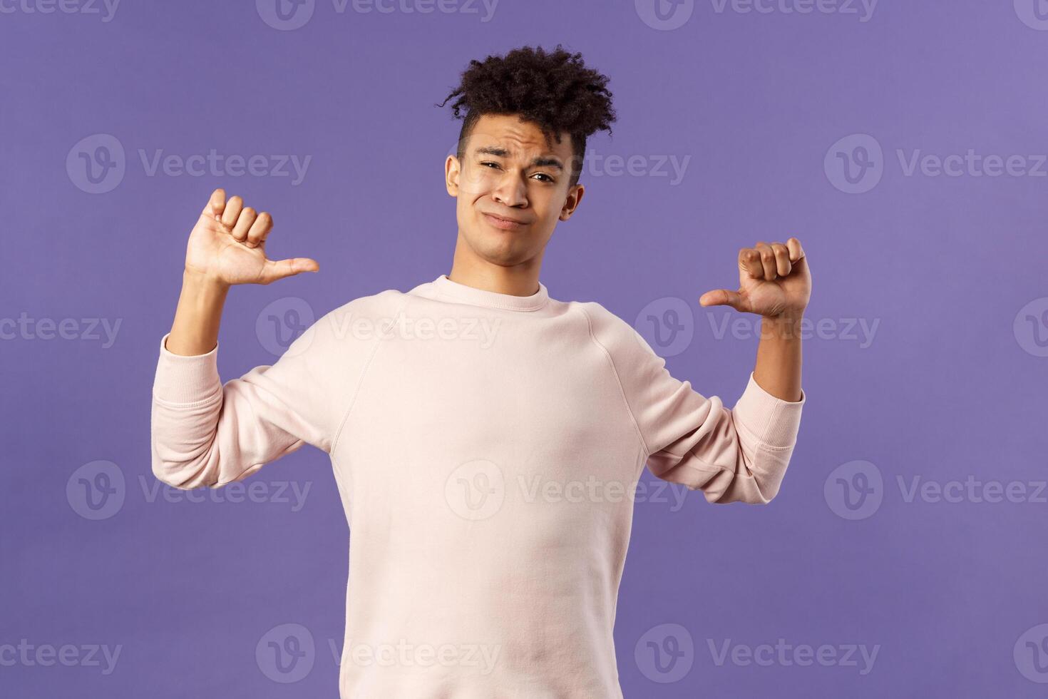 Portrait of boastful handsome young male student with dreads, bragging about how he workout in gym, show-off, pointing at himself and smirk self-assured, standing purple background photo