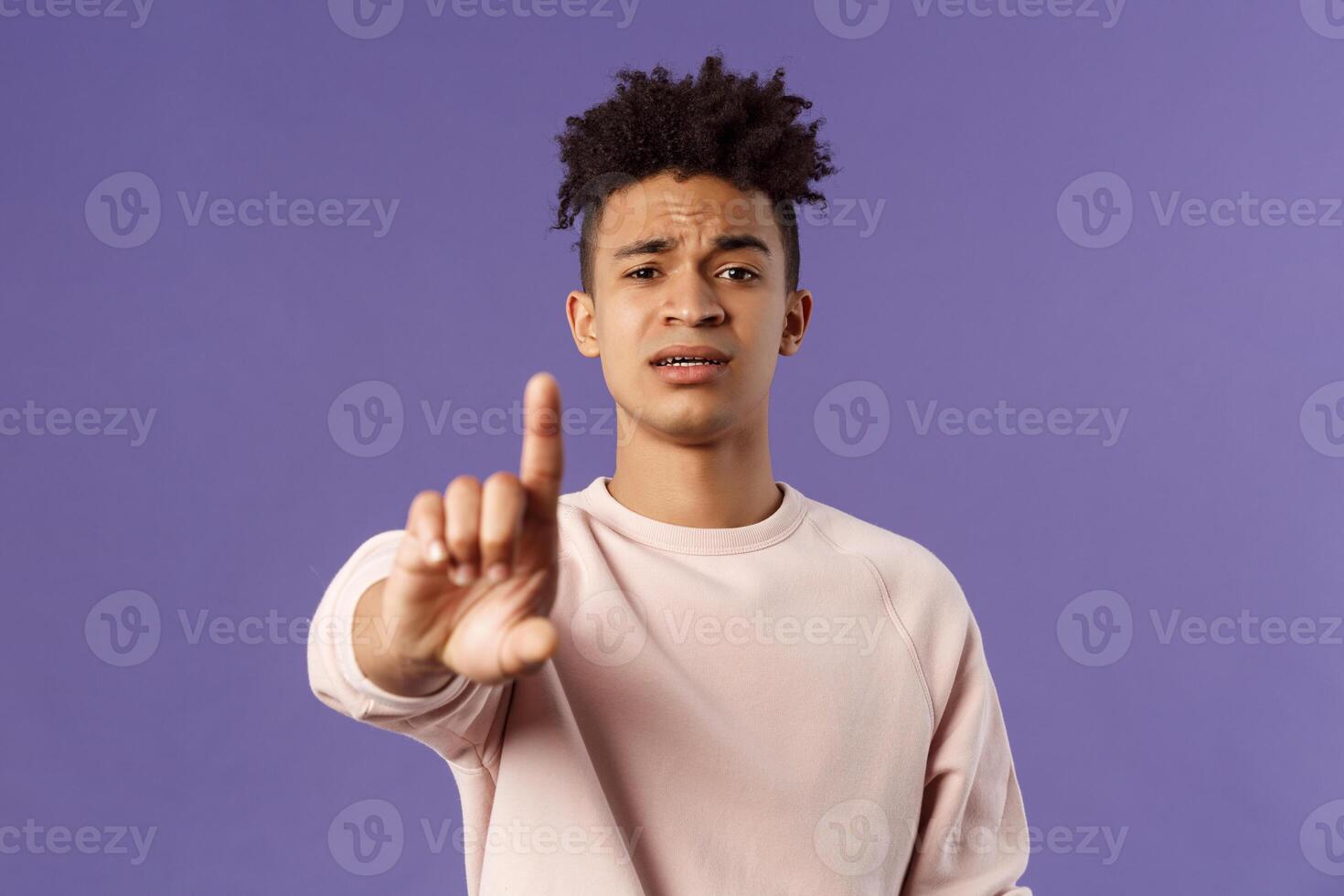 Close-up portrait of serious-looking hispanic man trying to prevent something bad, steping in for person being bullied, shaking index finger to scold wrong behavrious, forbid and prohibit something photo