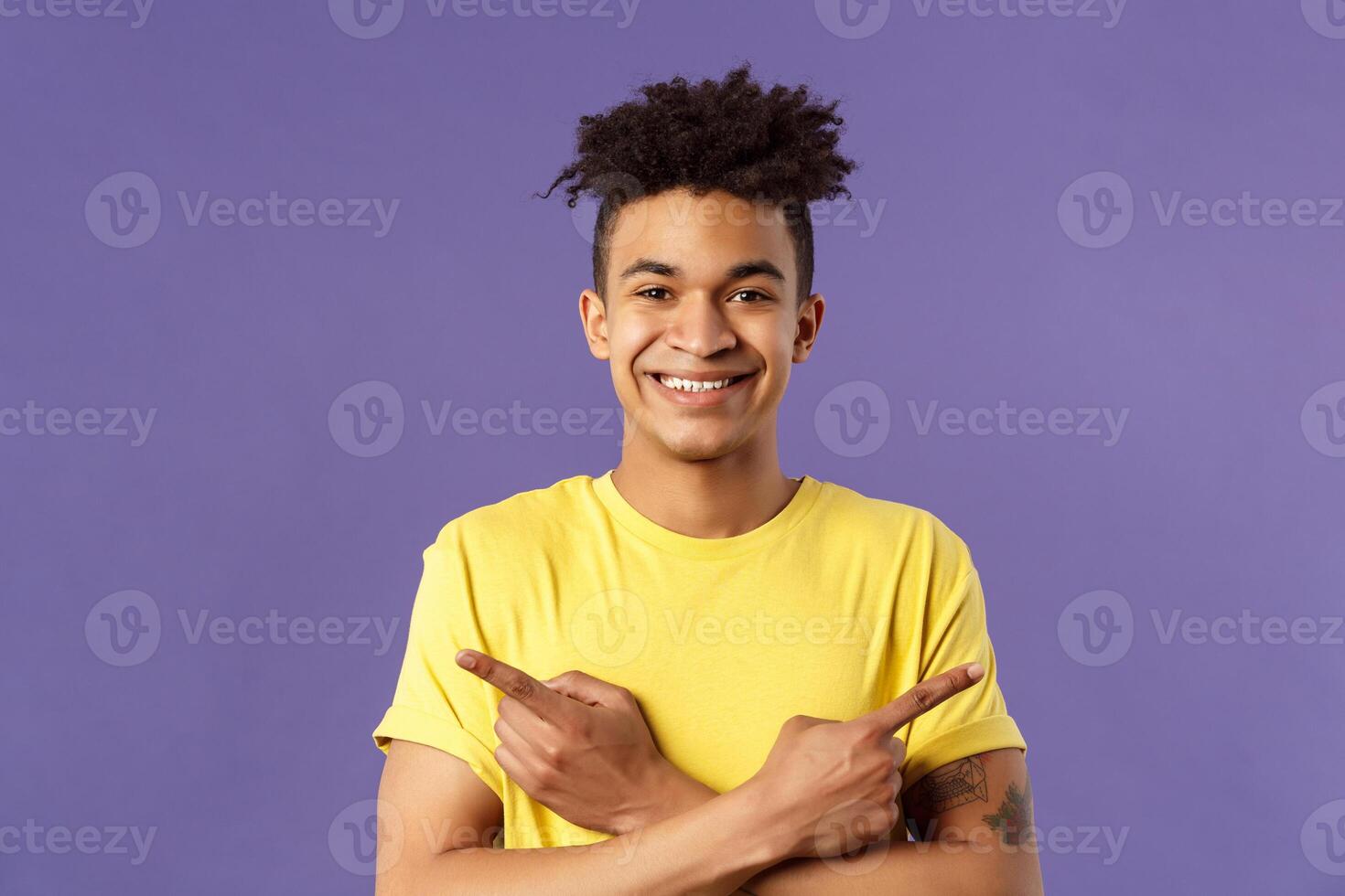 Close-up portrait of pleased, good-looking hispanic man promoting two products, showing both ways good, give variants, pointing fingers left and right, smiling recommend check out all photo