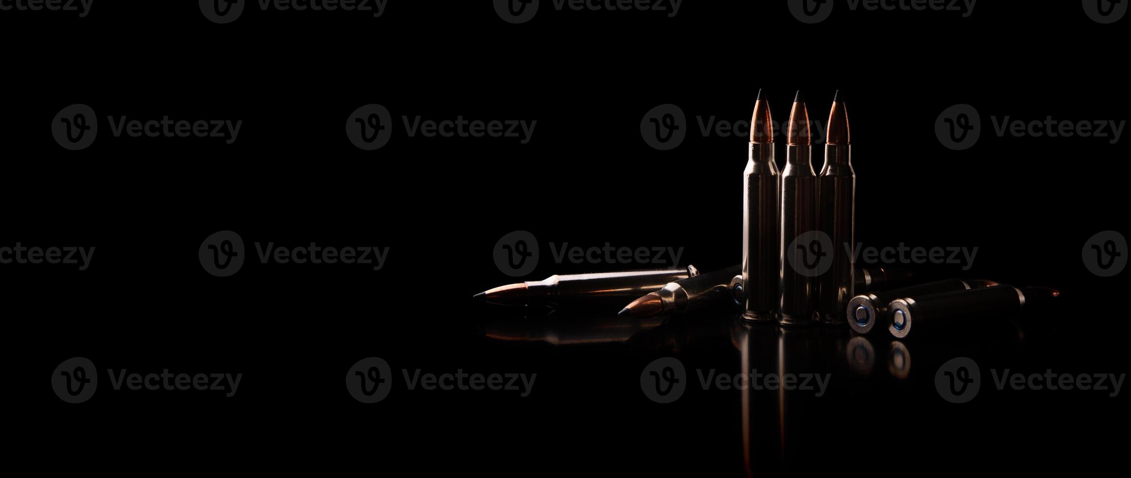 Bullet isolated on black background with reflexion. Rifle bullets close-up on black back. Cartridges for rifle and carbine on a black. photo