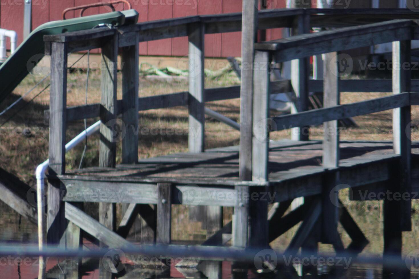A Small Dock On The Side Of A Pond In The Rural Country photo