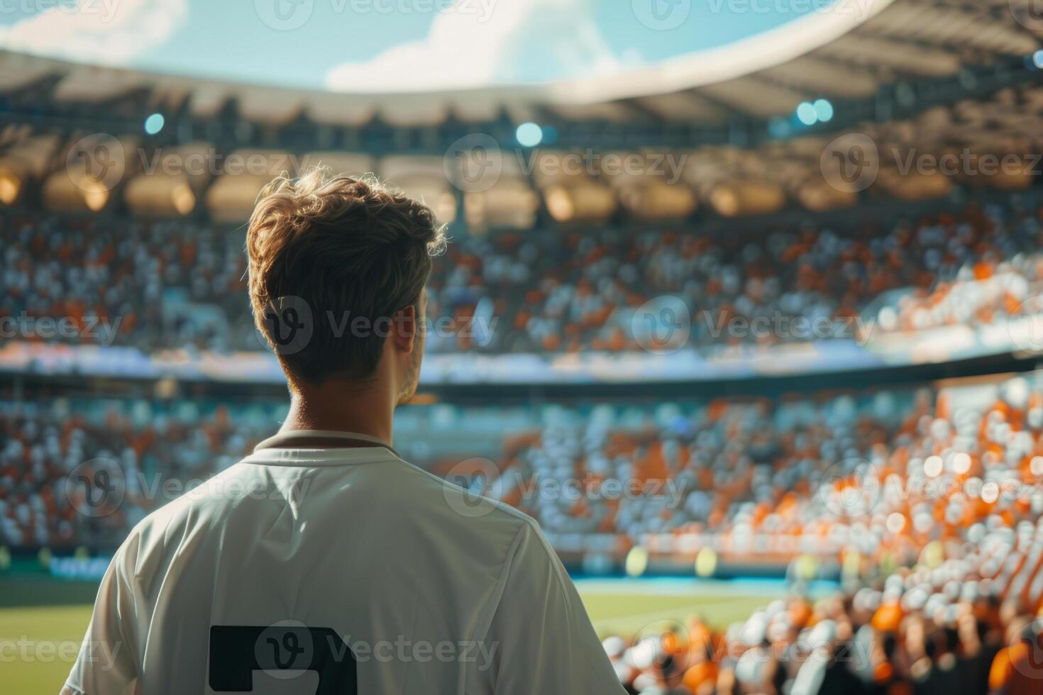 Soccer player standing on the field, preparing for a match in a large stadium photo
