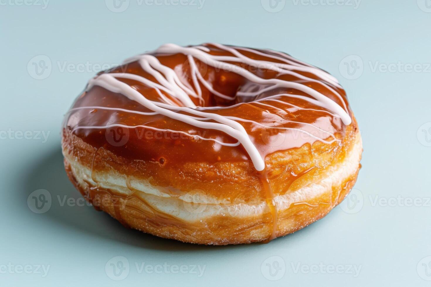 A tempting chocolate covered donut is showcased, adorned with a creamy drizzle, resting against a soft pastel backdrop that enhances its sweet allure. photo