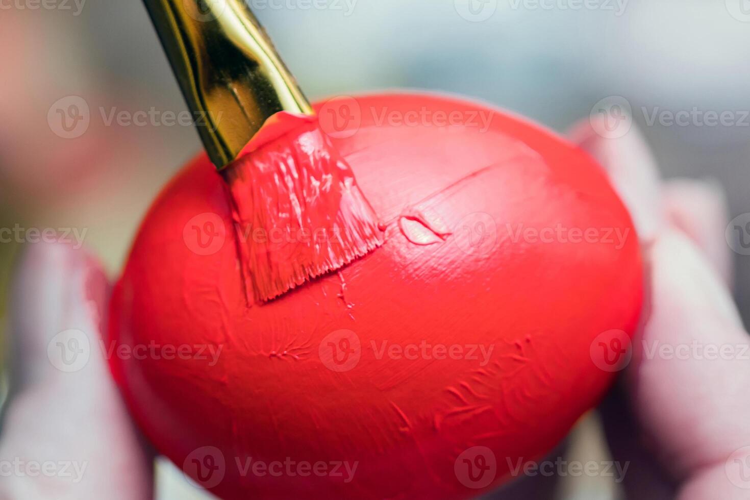 Chicken egg paint with a brush in red photo
