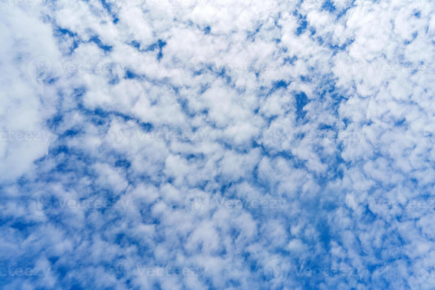 White clouds in the blue sky. Summer cloudy weather. Light natural background. photo