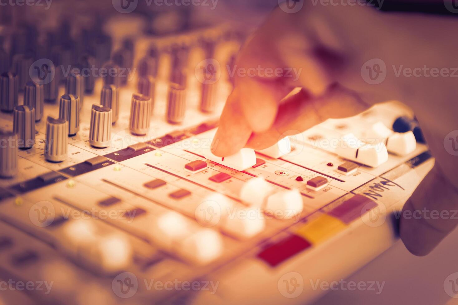 finger of engineer or music producer controlling sound recording studio mixing desk photo