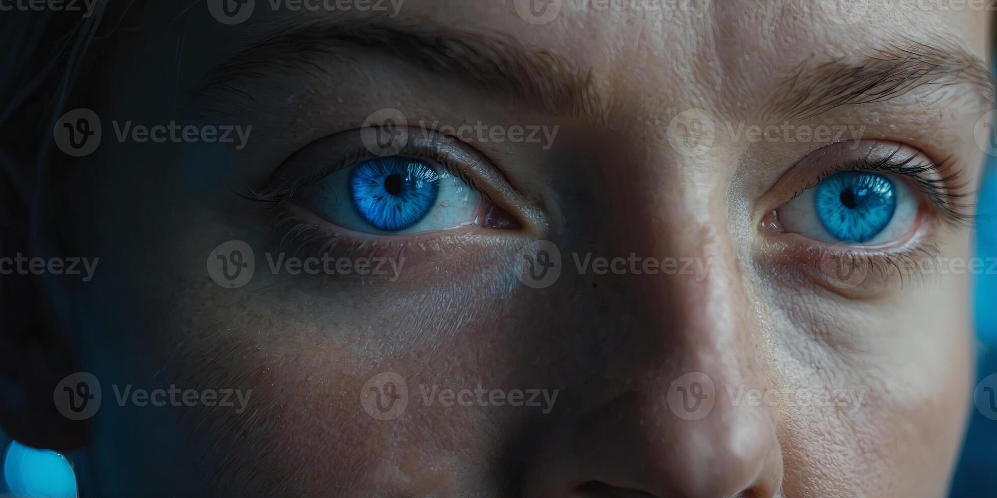 a persons face showcasing their vivid blue eyes, expressing intensity and emotion. photo
