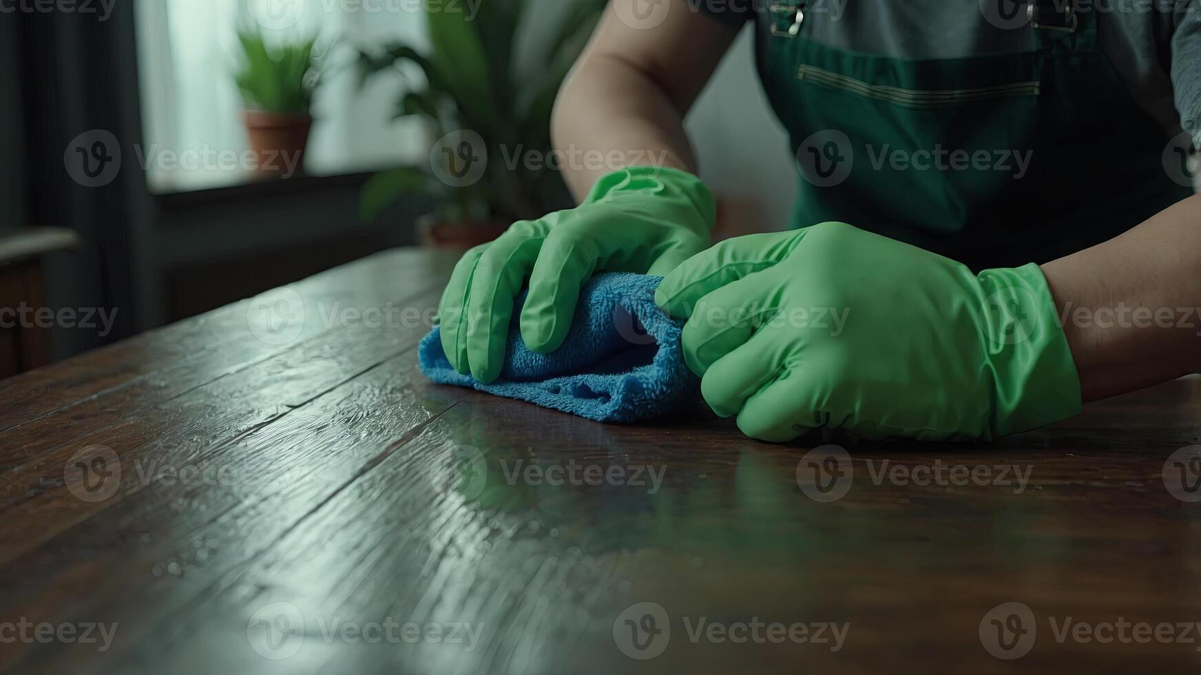 Person in green gloves cleaning a table Suitable for household cleaning products advertising. . photo
