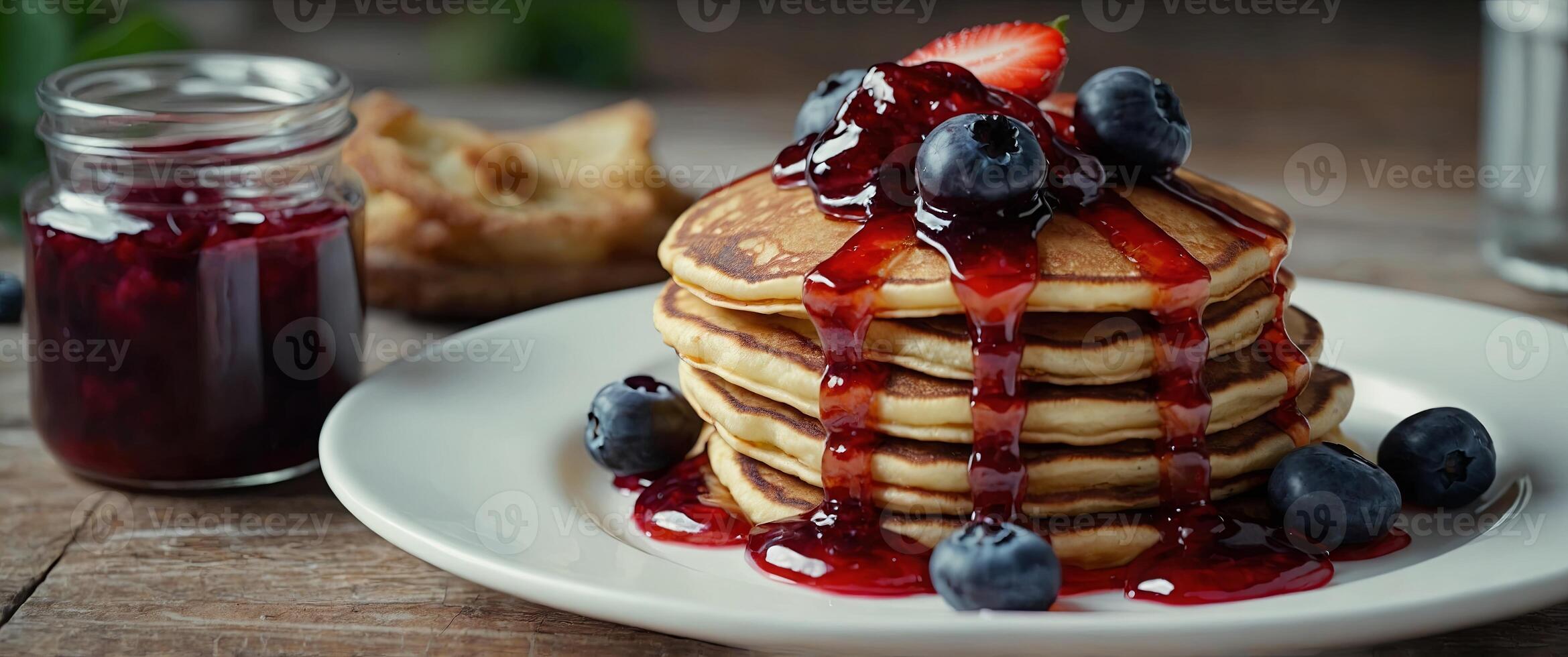 Stack of american pancakes or fritters with strawberry and blueberry jam in white plate on wooden. photo
