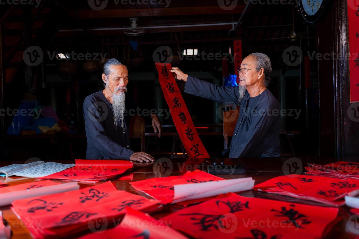 old scholars writing calligraphy at lunar new year. Calligraphy is a popular tradition during Tet holiday. Text in photo mean Happy New Year and Peace.