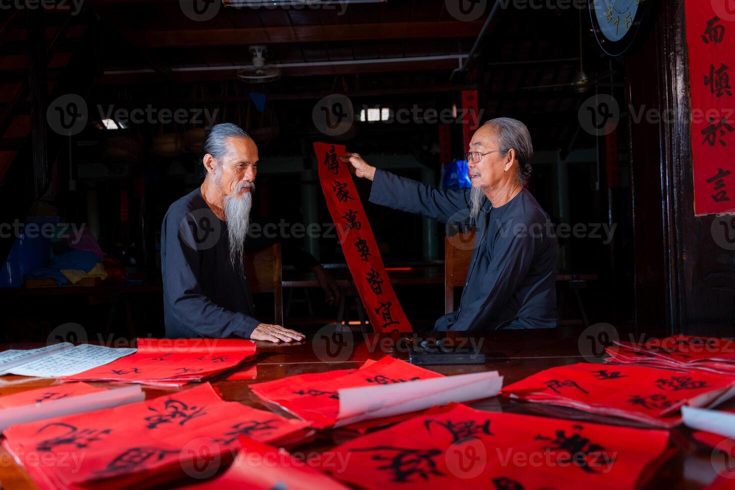old scholars writing calligraphy at lunar new year. Calligraphy is a popular tradition during Tet holiday. Text in photo mean Happy New Year and Peace.