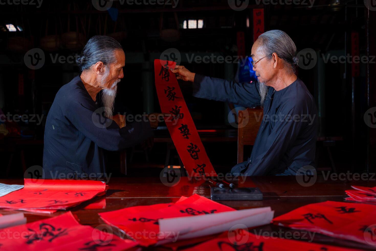 old scholars writing calligraphy at lunar new year. Calligraphy is a popular tradition during Tet holiday. Text in photo mean Happy New Year and Peace.
