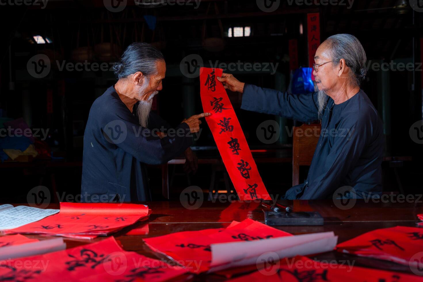 old scholars writing calligraphy at lunar new year. Calligraphy is a popular tradition during Tet holiday. Text in photo mean Happy New Year and Peace.