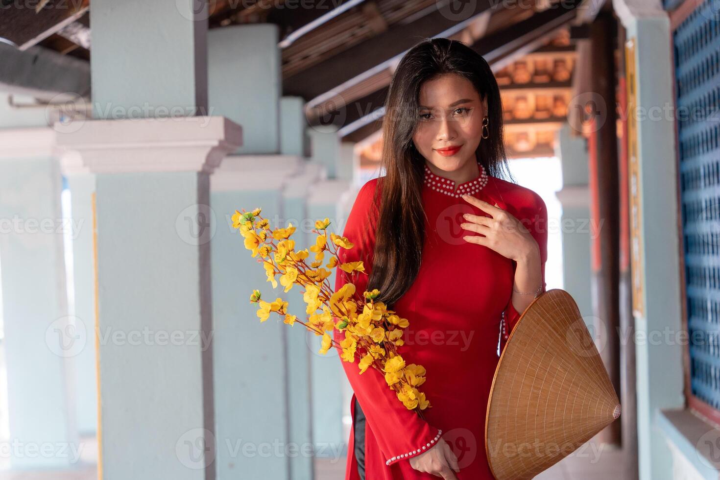 Vietnamese girl with Ao Dai dress standing in traditional house of Vietnam. Text in photo mean best wishes to family, happiness, prosperity, health. Tet holiday and New Year.