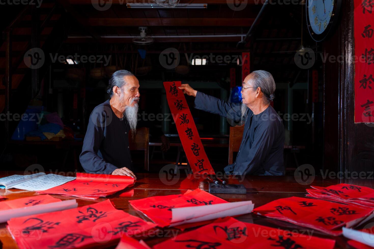 old scholars writing calligraphy at lunar new year. Calligraphy is a popular tradition during Tet holiday. Text in photo mean Happy New Year and Peace.